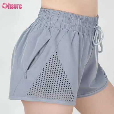 Großhandel Damen Sport Workout Shorts Atmungsaktive Laser Cut Jogging Shorts mit Warm-up Reißverschluss Seitentasche Einfarbig